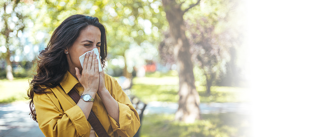 Senior woman blowing nose in napkin